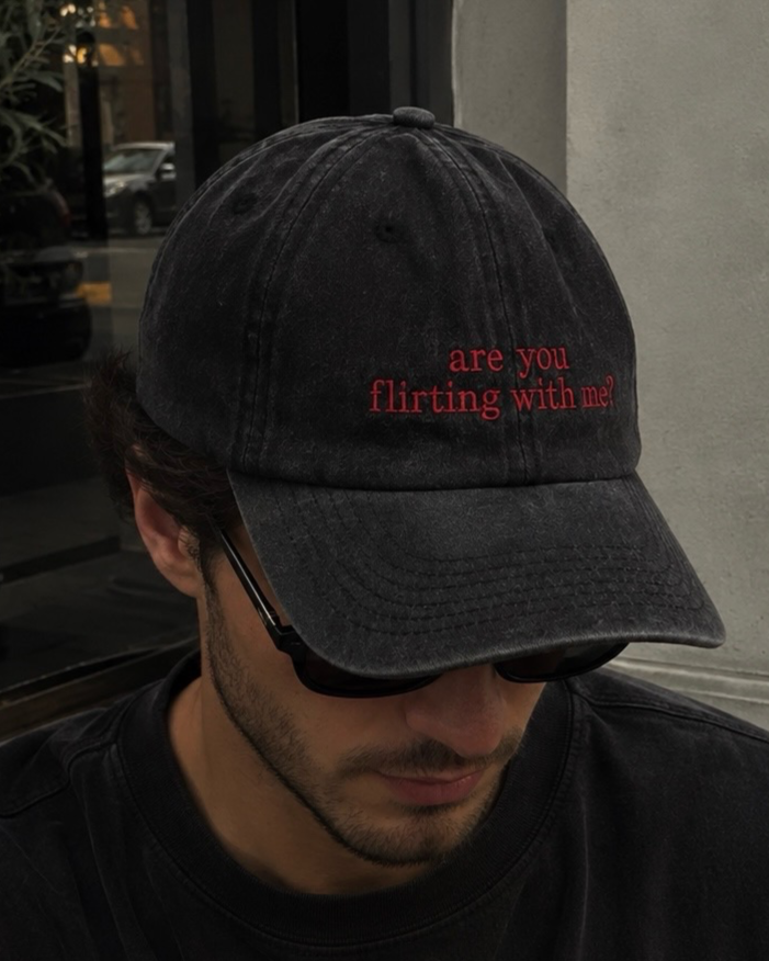 Gorra negra de Peruvian Cool Club con acabado deslavado y frase bordada en rojo vino: “Are You Flirting with Me?”.