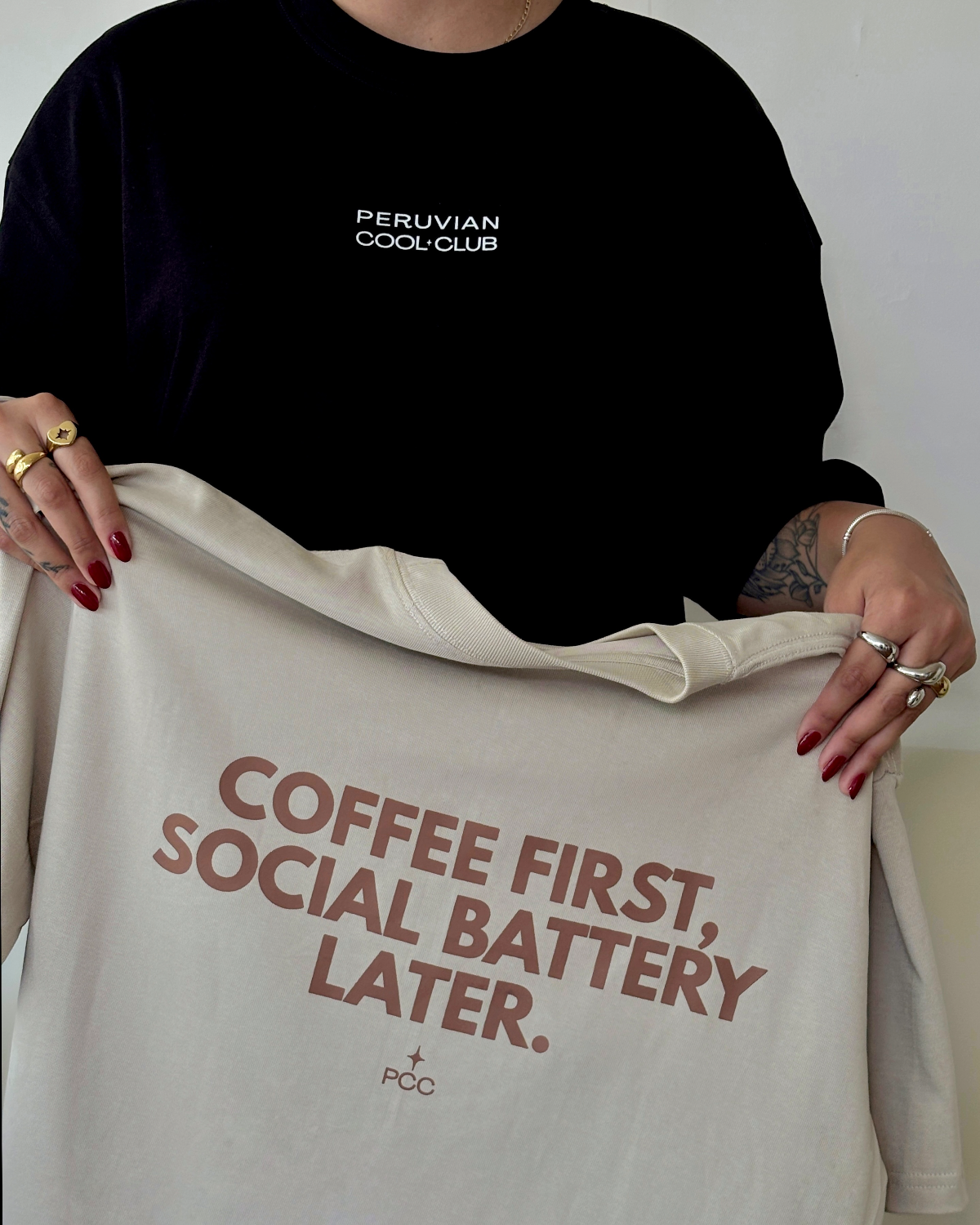Polo oversize beige de Peruvian Cool Club con estampado color marrón cocoa “Coffee First, Social Battery Later”.